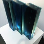 a 3d layered glass trptych artwork portraying a noir urban landscape deep in the heart of the city. Shadowy buildings, glowing streetlights and windows rendered in stacked transluscent layers of glass, creating depth, mystery and cinematic atmosphere