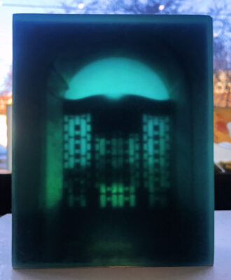 A magical 3D glass sculpture depicting an Art Noveau portal set deep within layers of transluscent glass that captures and refracts light in etheral hues